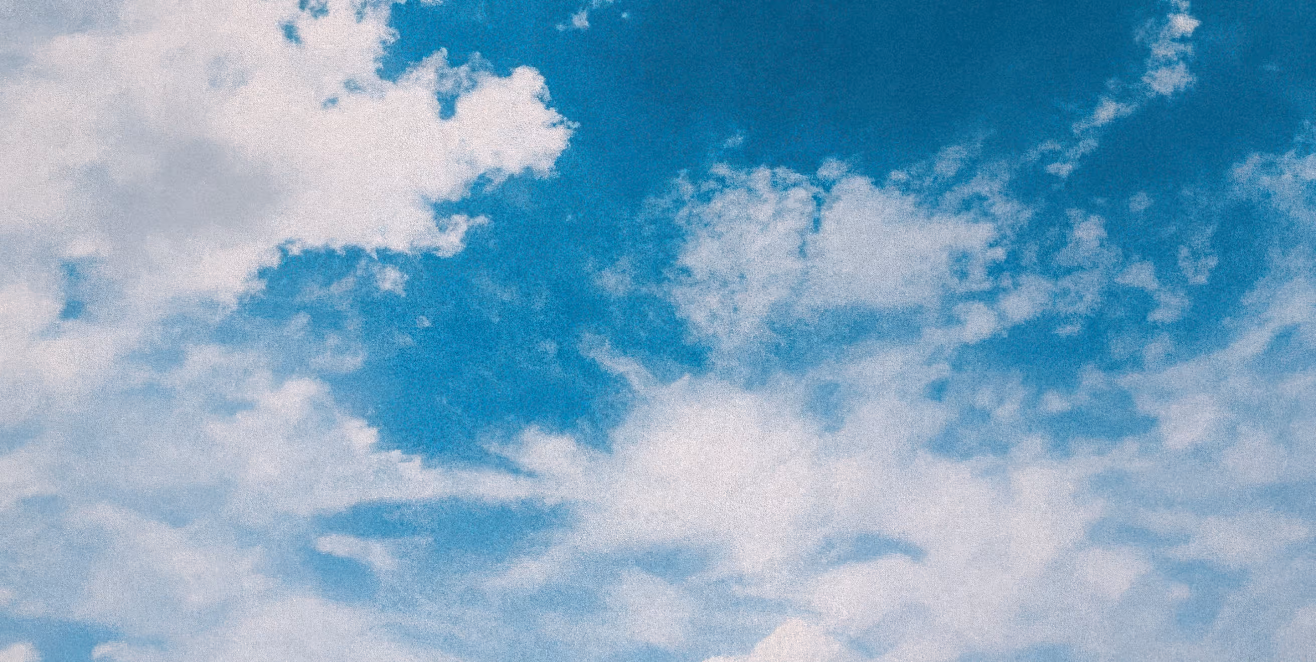 Blue sky with scattered white clouds.