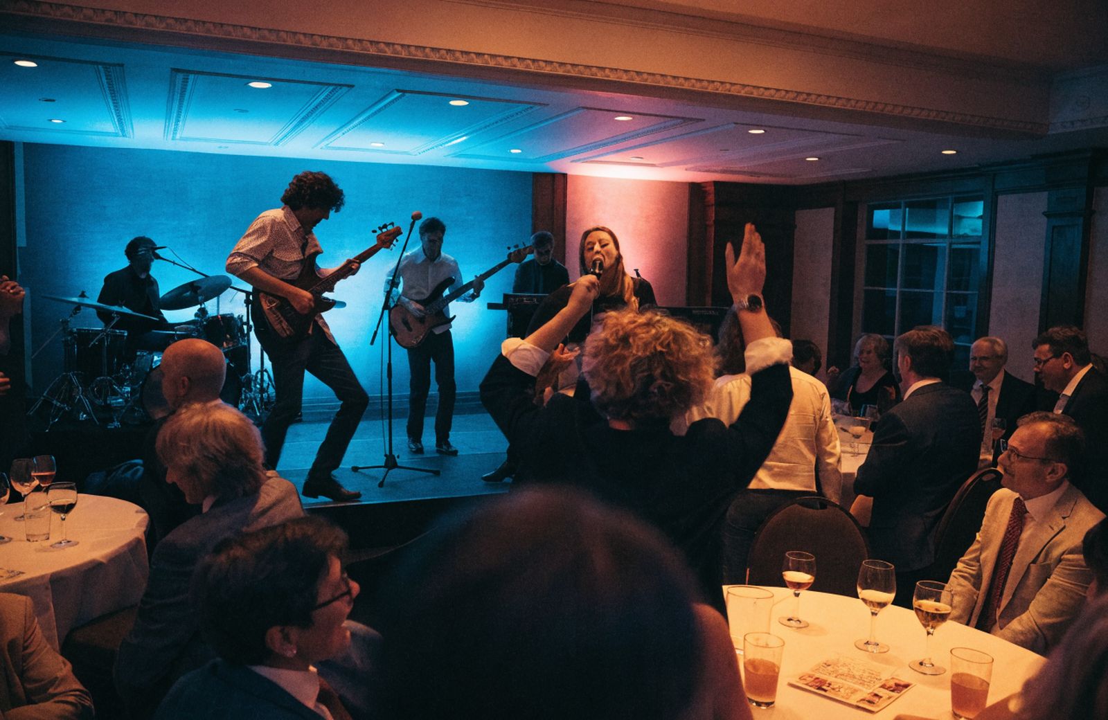 A function band playing to a full room of guests at a charity fundraising evening
