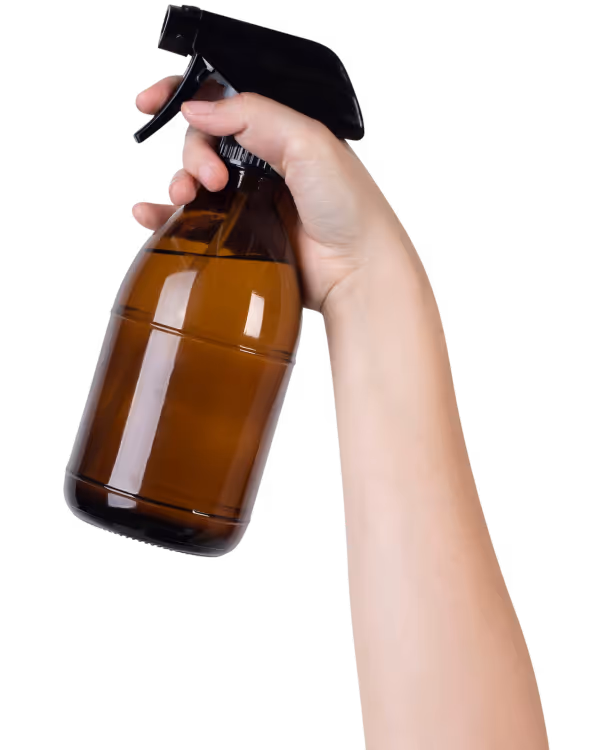 Eine Hand hebt eine braune Sprühflasche in die Luft.