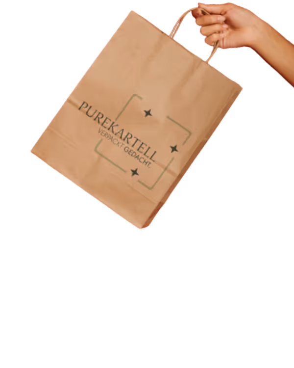 Eine Tüte mit dem Aufdruck Purekartell wird in der Hand gehalten.