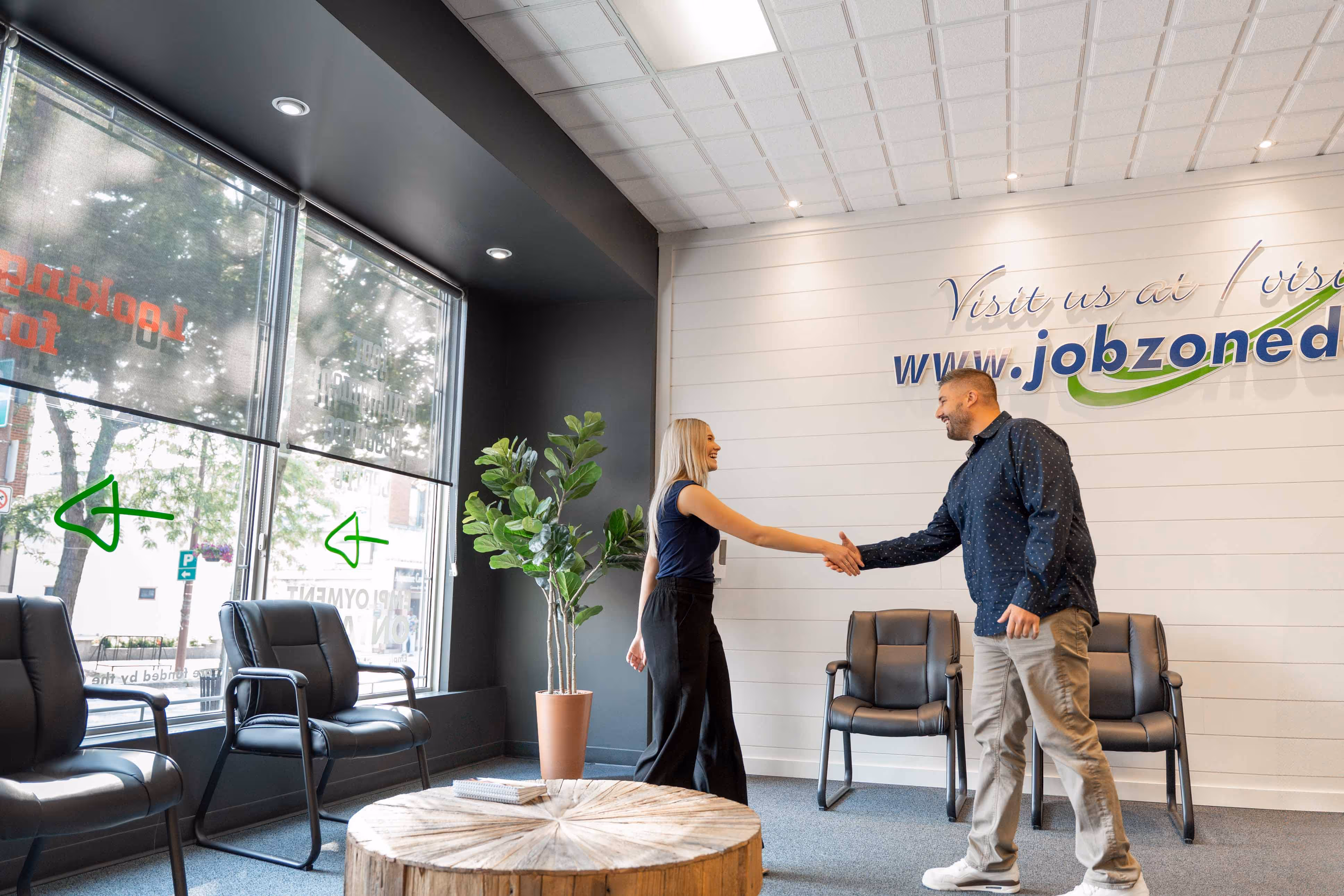 Job counsellor at Job Zone d'emploi welcoming client at front lobby area; shaking hands