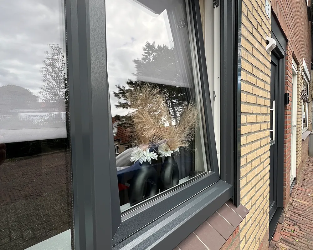 Donkergrijs kunststof kozijn met draai-kiepraam, geplaatst door Brands Kozijnen & Geveltechnieken.