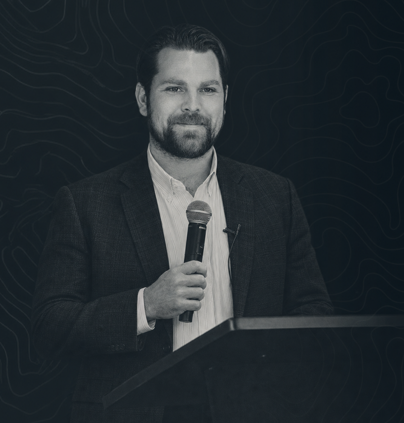 Josh Donnelly speaking at a podium with a microphone
