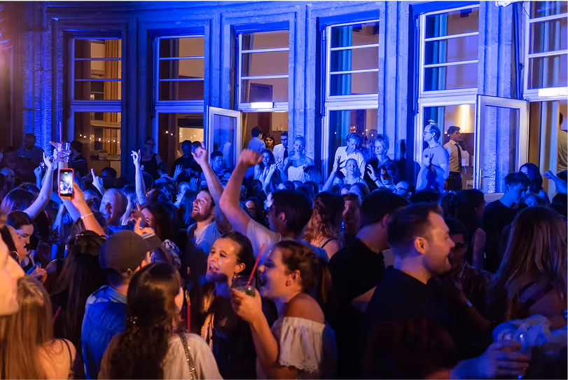 Ausgelassene Partynacht mit Gästen vor Schlosskulisse – Licht- und Eventinszenierung von Marcel Mäder – Gravity