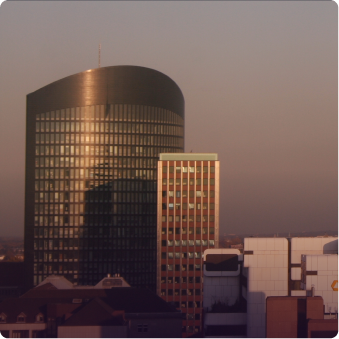 Sonnenbeleuchtete moderne Bürogebäude bei Sonnenuntergang in einer Stadt.