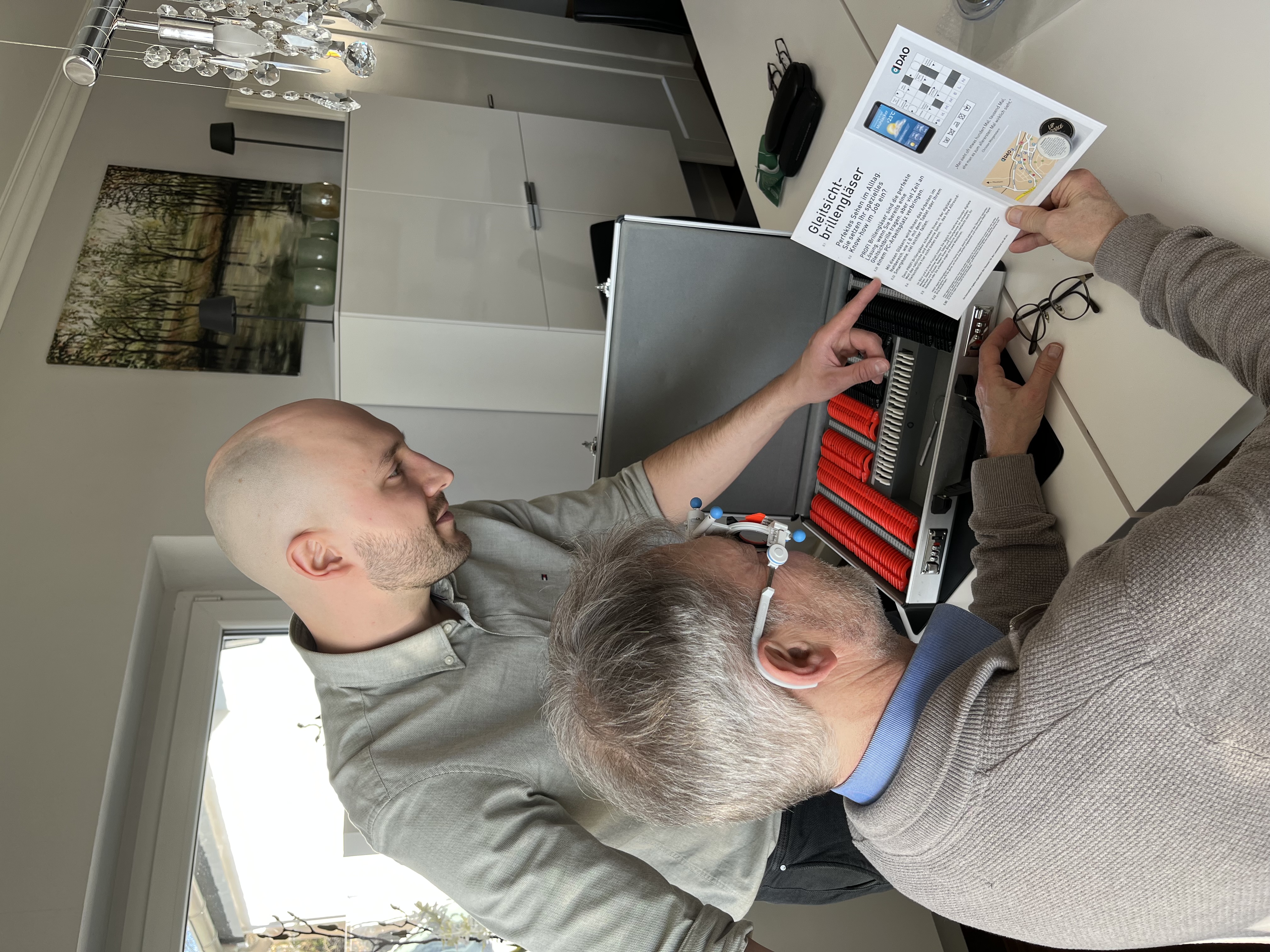 Eine Person nutzt ihre vergrößernde Sehhilfe bzw. Lupe um ein Buch zu lesen nach erfolgreicher Low-Vision-Beratung in Solingen