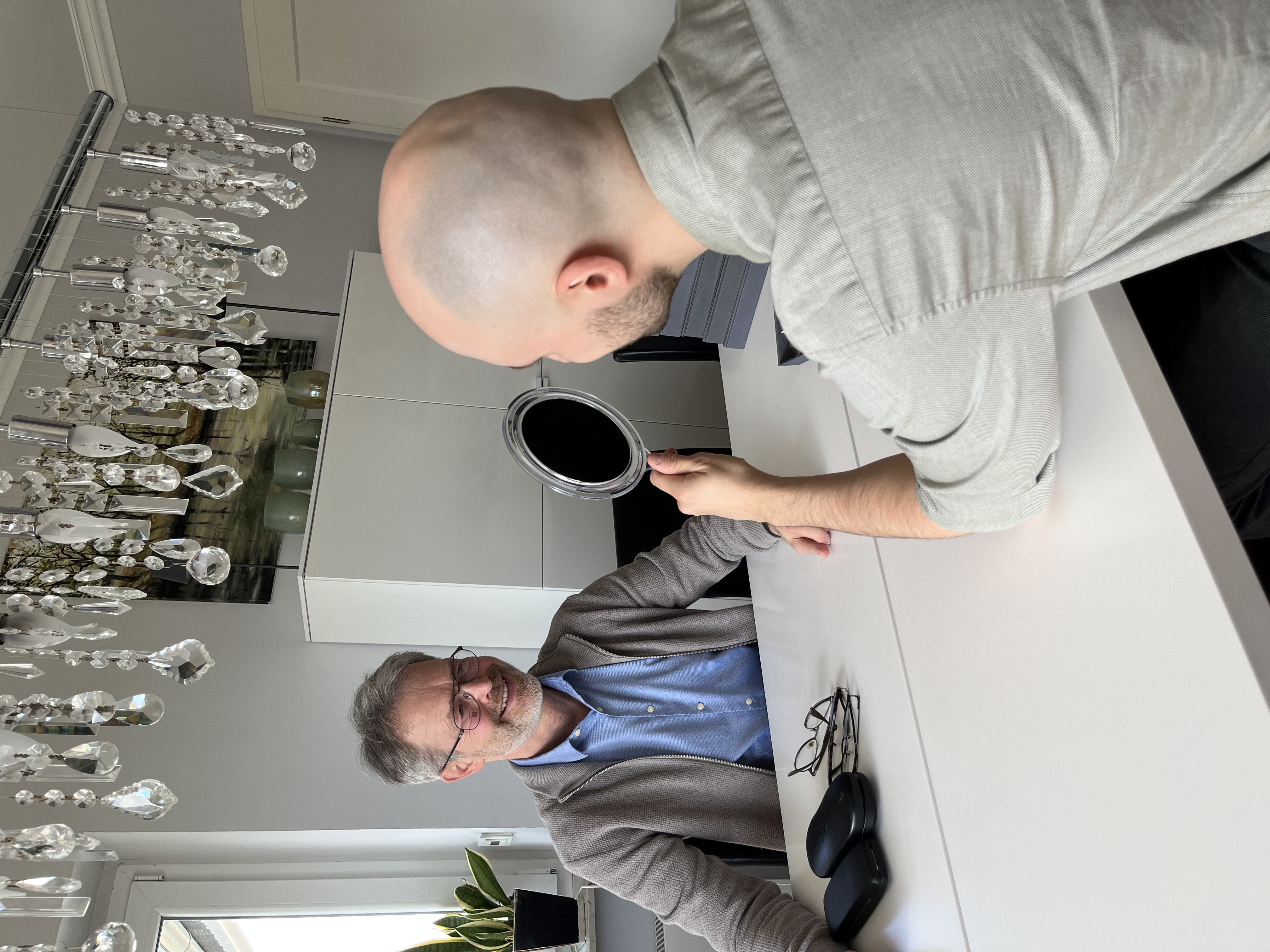 Eine Frau steht vor dem Spiegel und probiert glücklich ihre neue Brille von Brillen Zuleger - Ihrem mobilen Optiker an