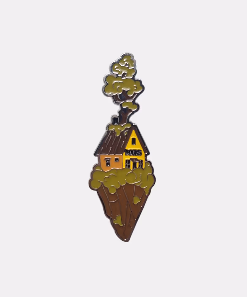 Limited edition enamel pin featuring detailed miniature house on a tiny planet, art merchandise by Michael Davydov