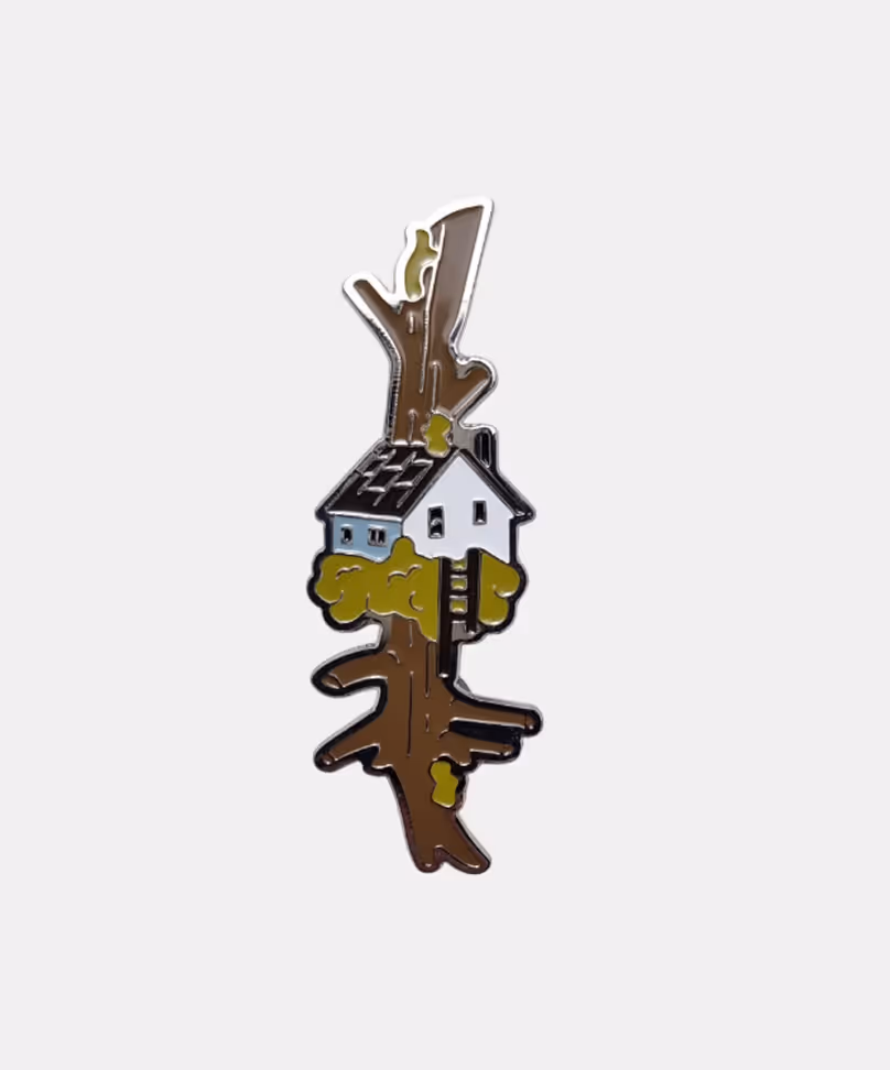 Limited edition enamel pin featuring detailed miniature house on a tiny planet, art merchandise by Michael Davydov
