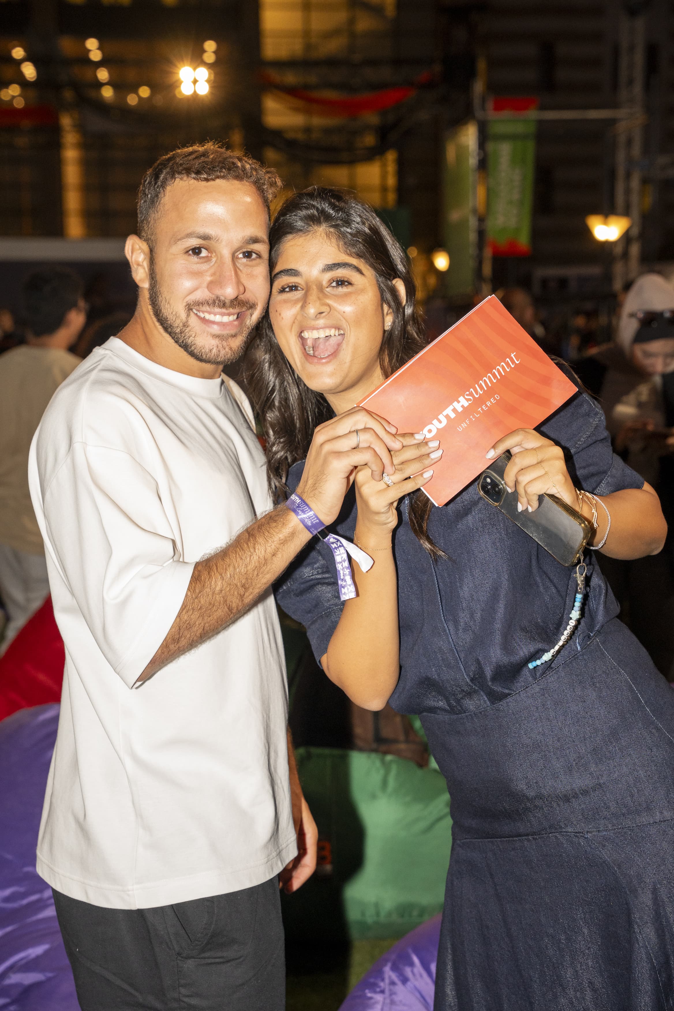 Two attendees holding a festival ticket