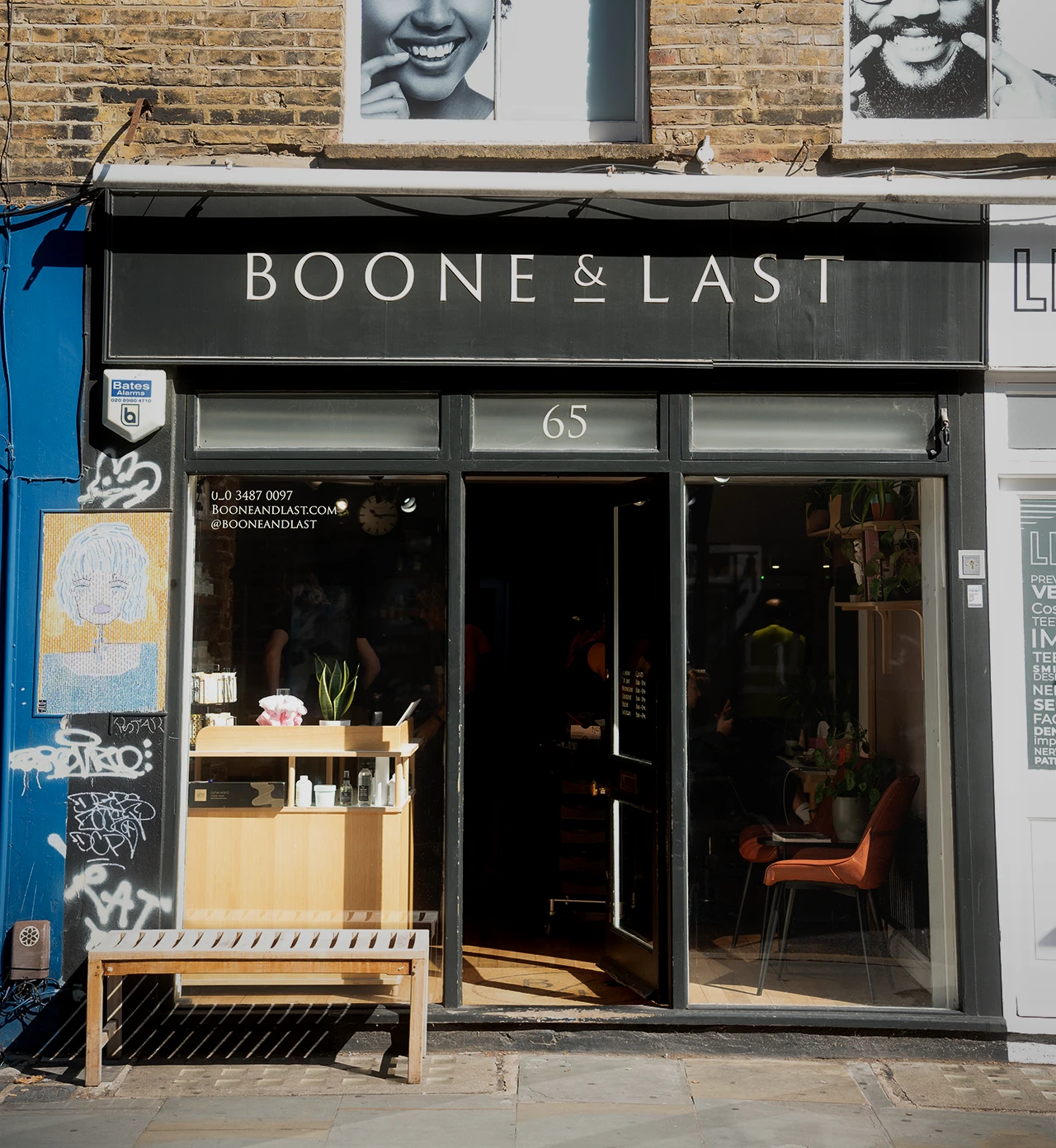 Front view of Boone & Last salon with open door, wooden bench outside, and interior visible through glass window.