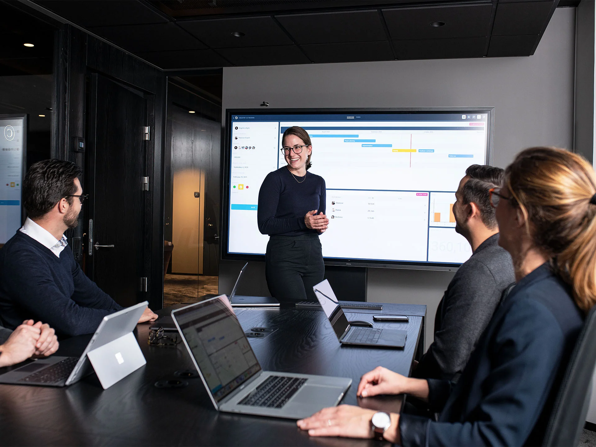 Team meeting with Mevisio platform displayed on screen.