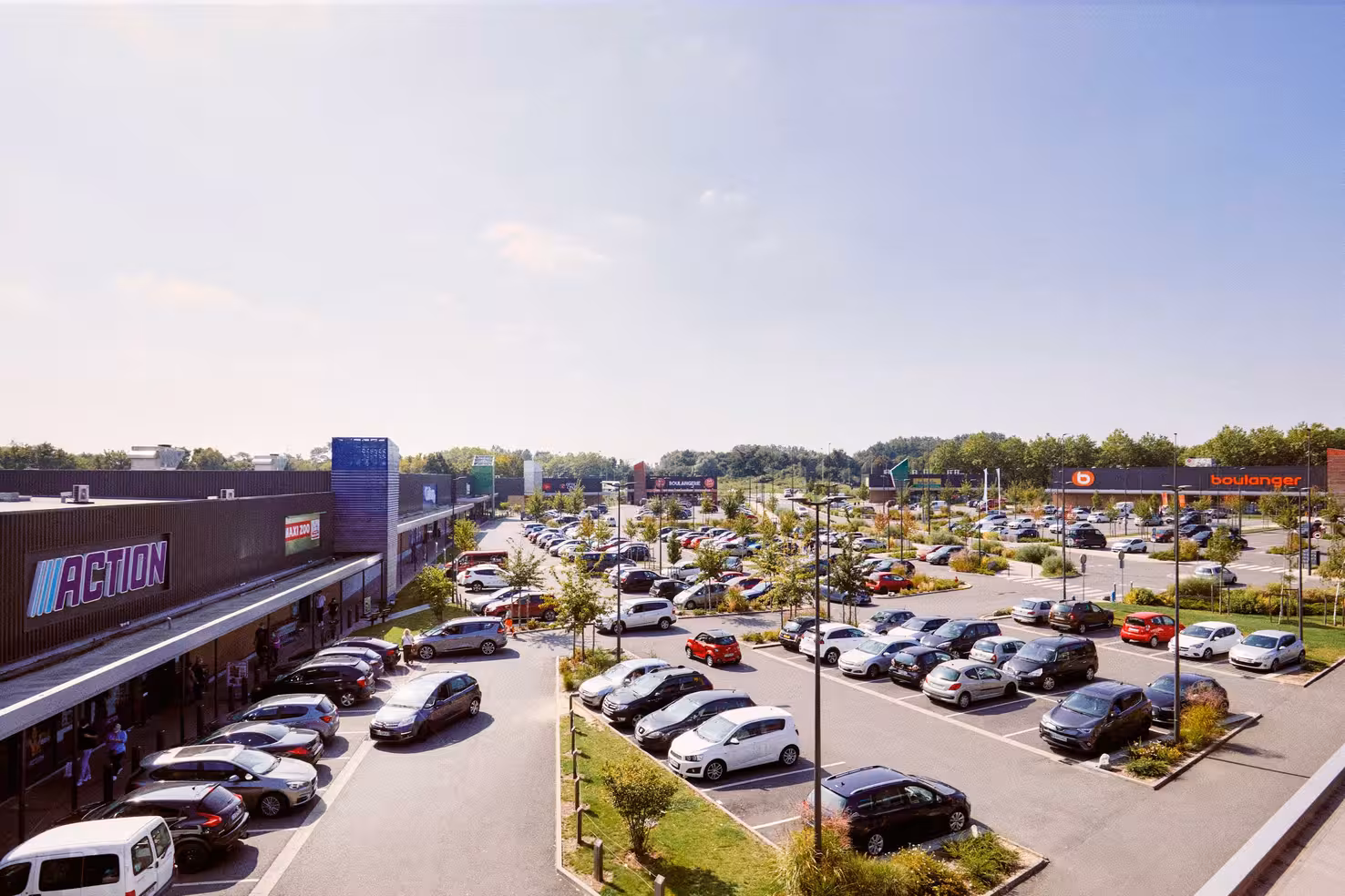 Vue aérienne d'un parc commercial avec enseignes de magasins et grand parking
