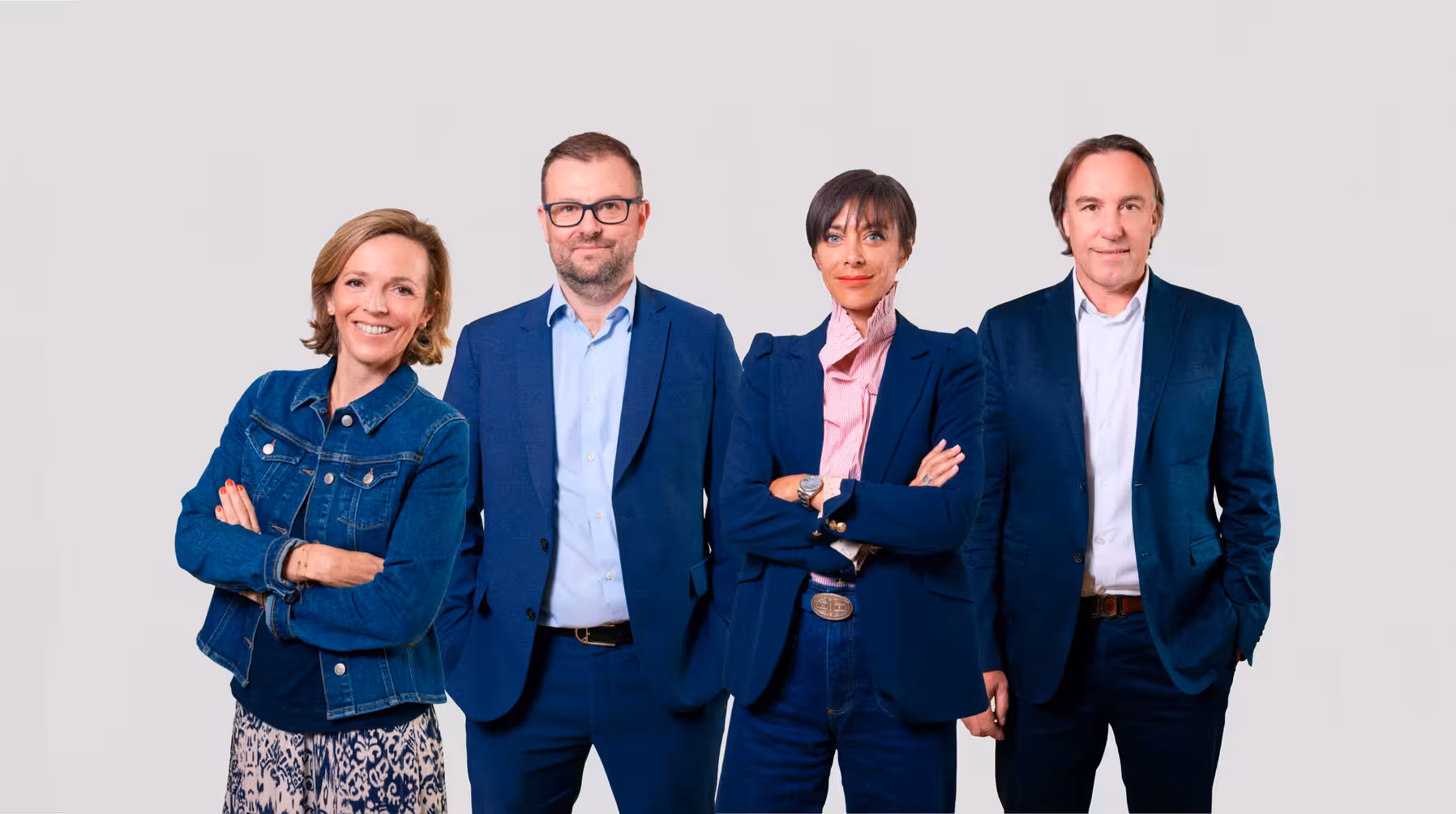 Quatre membres de l'équipe de Mata Capital en tenue professionnelle posant ensemble sur fond gris uni