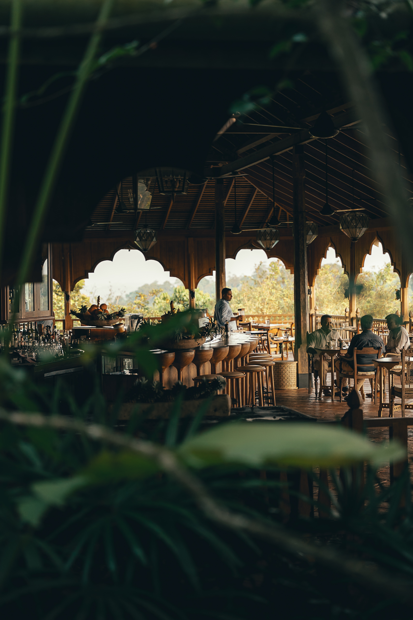 The open-sided restaurant pavilion at Malabar Hill, framed by carved arches and jungle