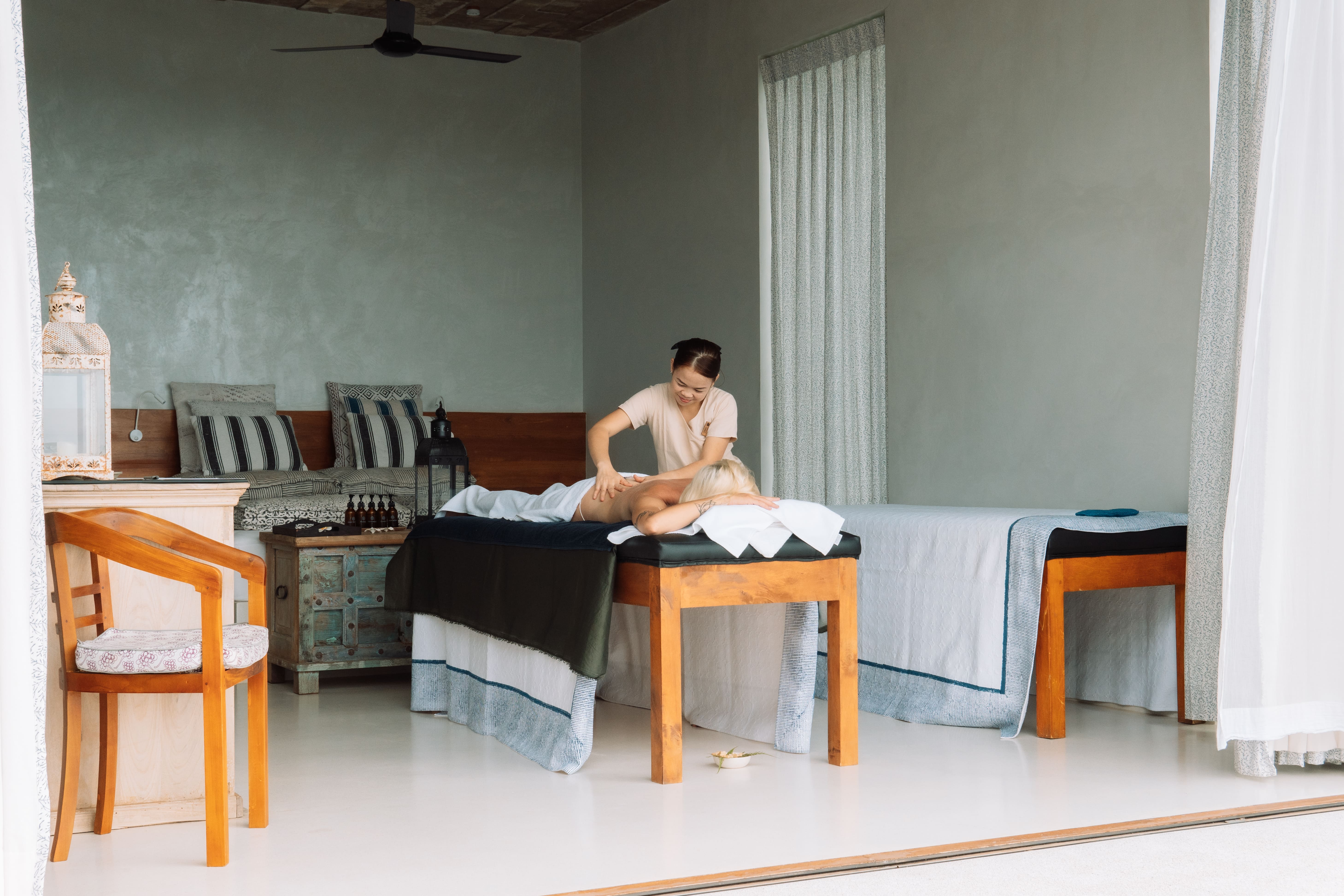 A therapist giving a massage in an open-sided treatment room at Malabar Hill