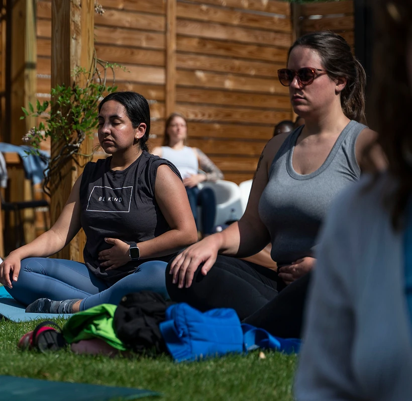 A group of women sitting on top of yoga mats.