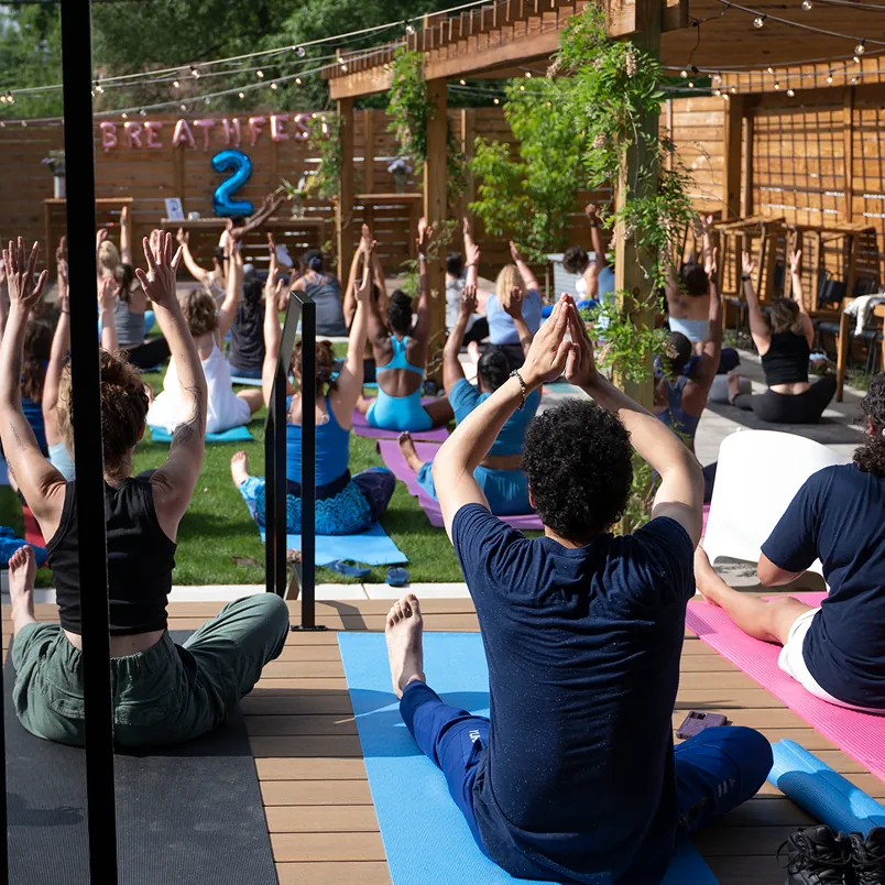 A group of people doing yoga in a park.