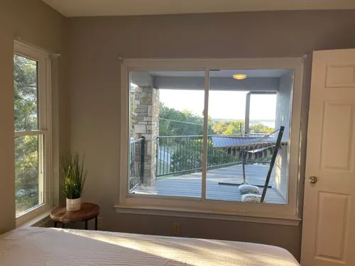 View from inside a bedroom with large window and outdoor patio.