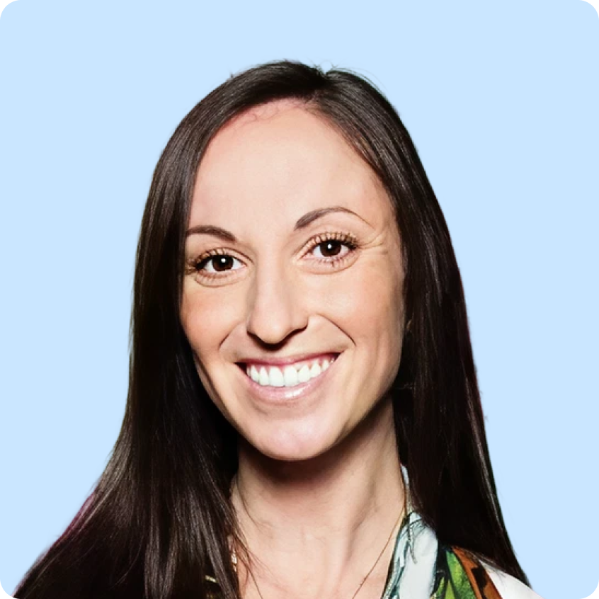 Smiling woman with long dark hair against a light purple background.