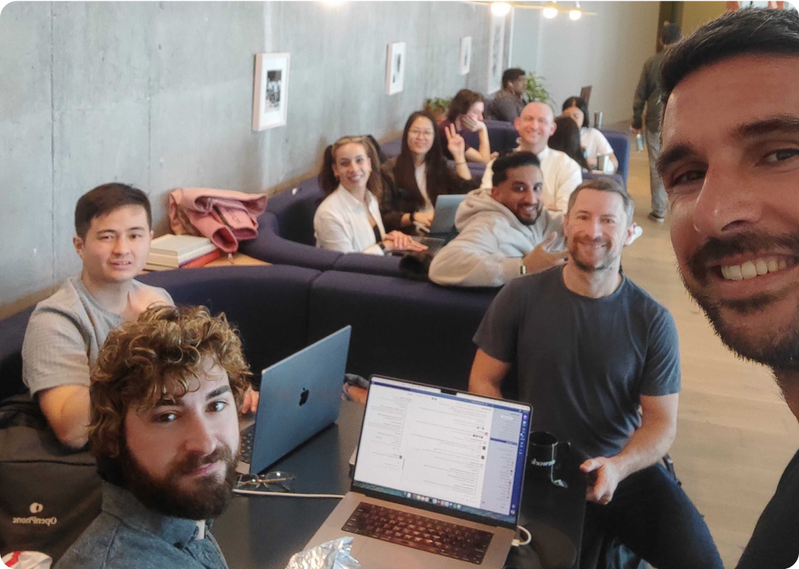 A group of people sitting in a room with a laptop on a table.