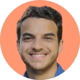 A man with a blue shirt and brown hair smiling at the camera.