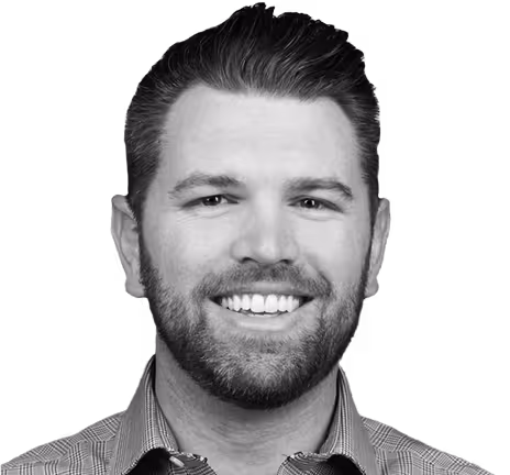 A man with a beard and mustache smiling at the camera.