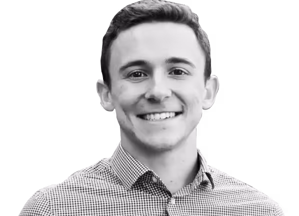 A man wearing a checkered shirt smiles for the camera.