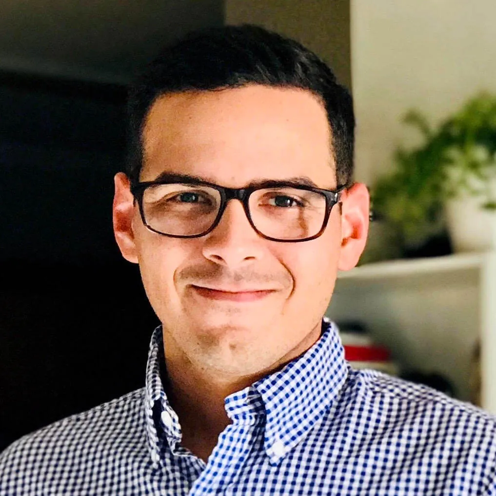 A man wearing glasses and a blue shirt.