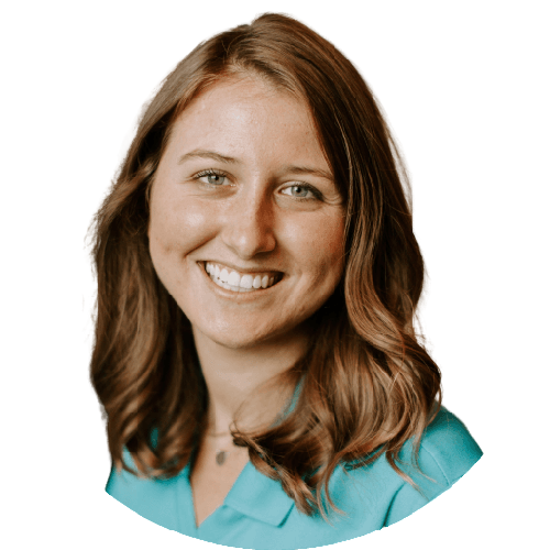 A woman with brown hair and a blue shirt smiling for the camera.