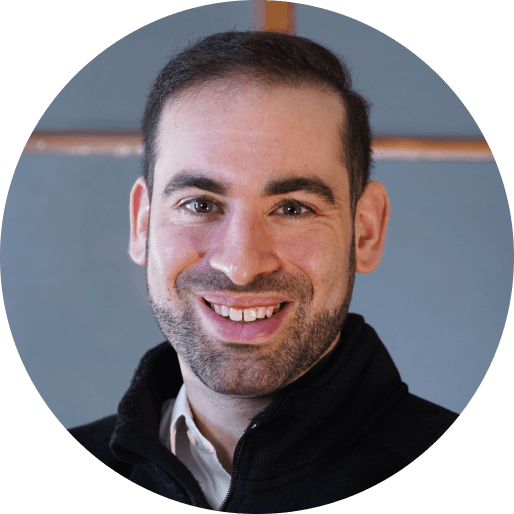 A man with a beard and mustache smiling at the camera.