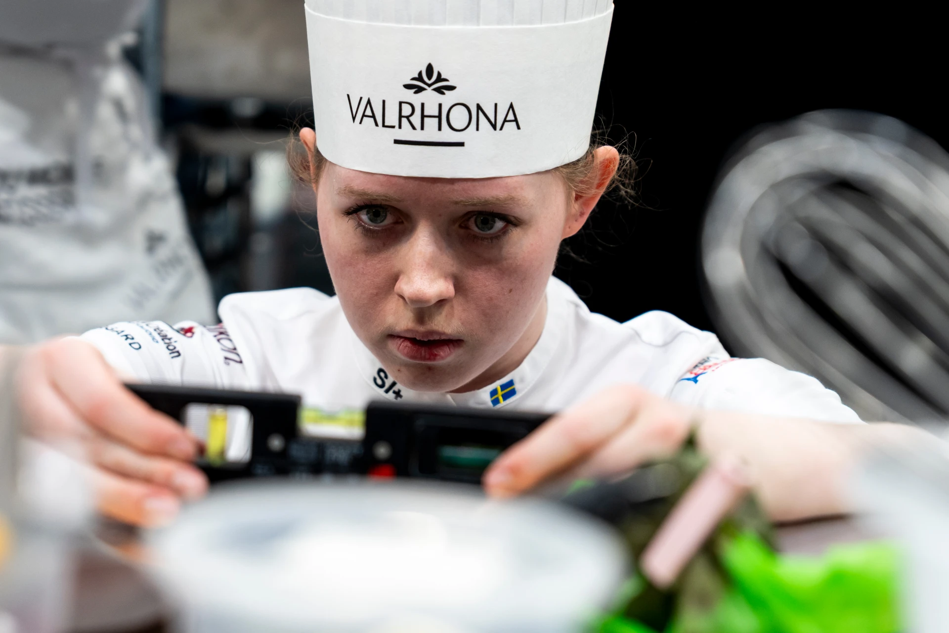 Michaela Andersten kontrollerar med vattenpass att en del av chokladskulpturen är jämn