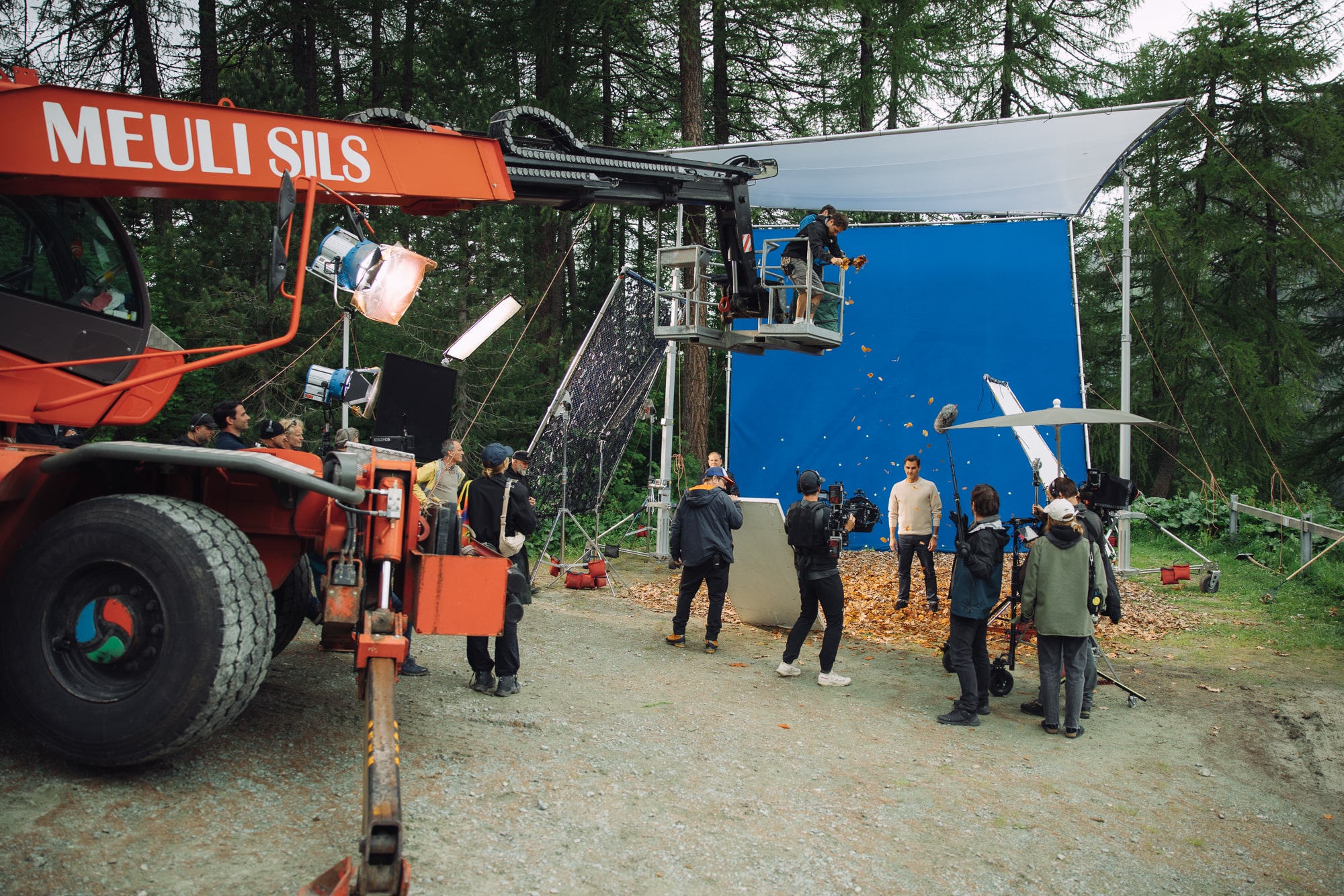 Film crew on a movie set with blue screen equipment in operation.