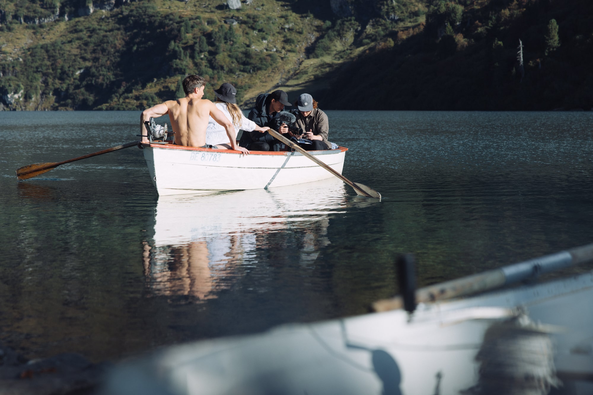 Rowers enjoy serene peaceful surroundings amidst lush greenery and majestic mountain landscapes.