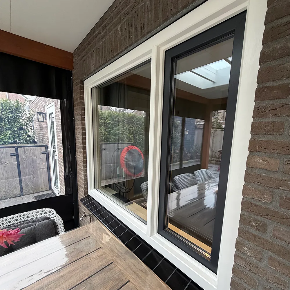 Wit kunststof kozijn met antraciet binnenzijde in bakstenen gevel, strak afgewerkt en voorzien van dubbele beglazing.