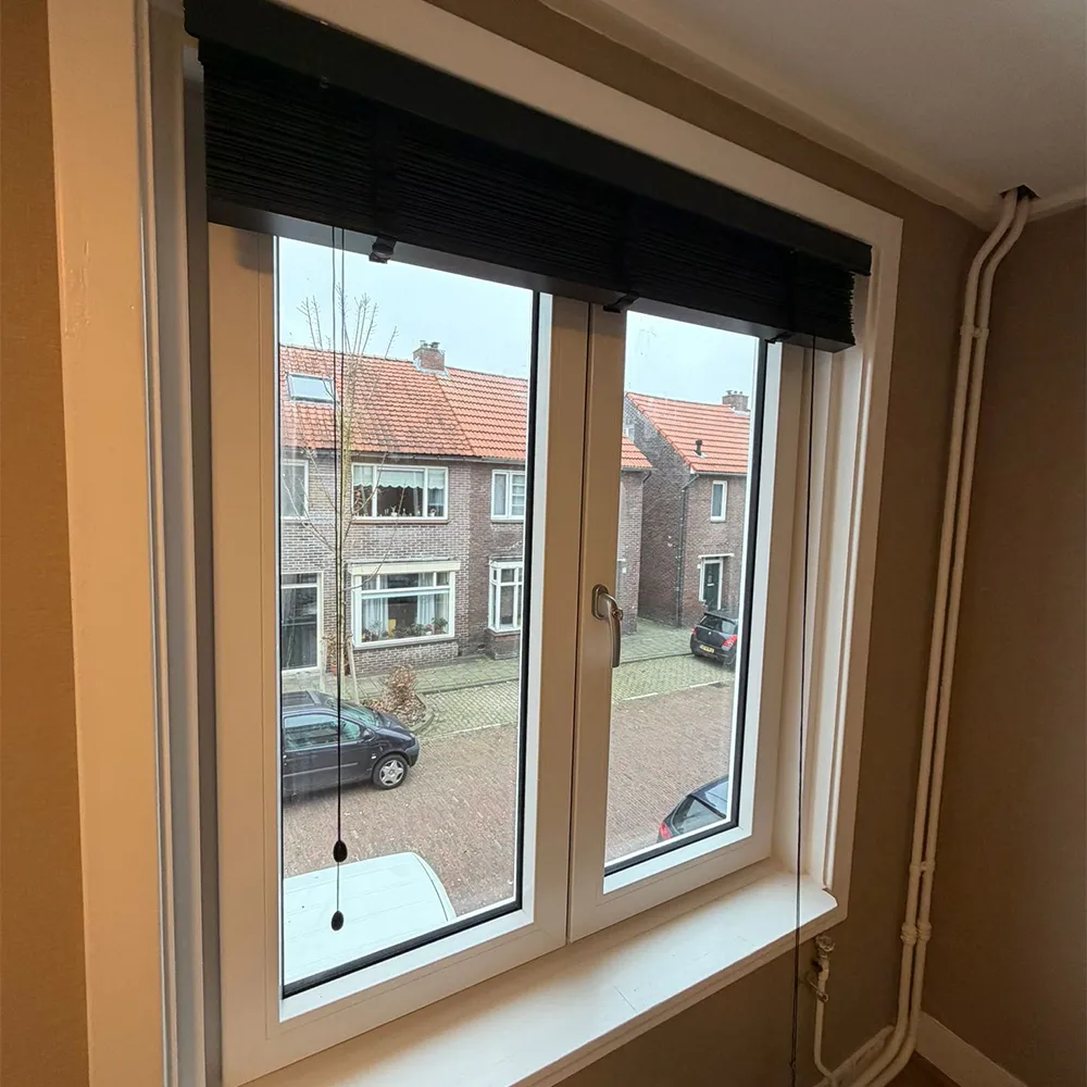 Wit kunststof draaikiepraam met dubbele beglazing en strakke afwerking aan de binnenzijde, geplaatst in bestaande woning.