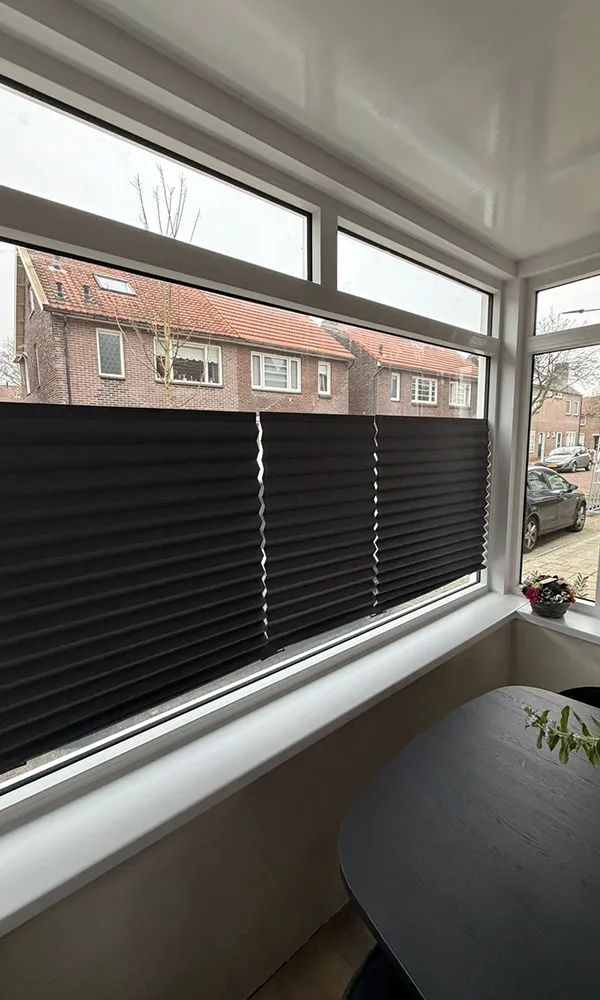 Wit kunststof kozijn met vaste raampartij en bovenlichten, voorzien van dubbele beglazing en strakke binnenafwerking.