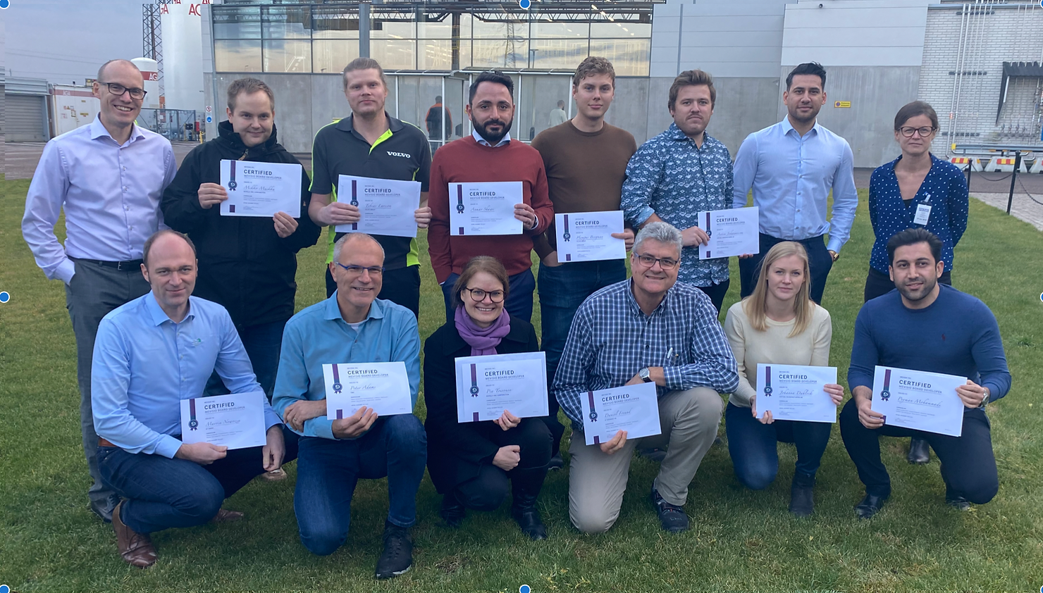 Group of professionals outdoors holding certificates after completing training.