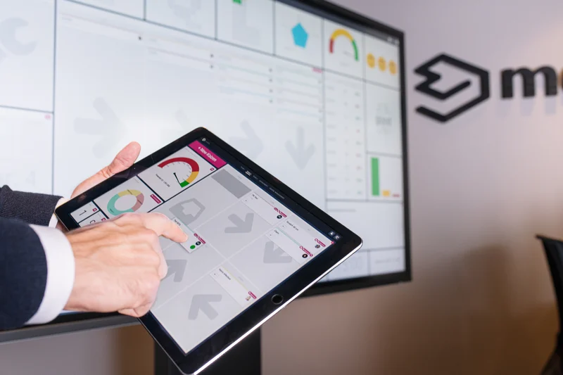 Person using a tablet connected to a large Mevisio dashboard