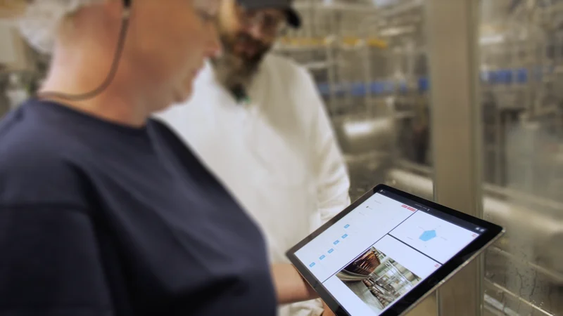Spendrups employees using a tablet beside production equipment