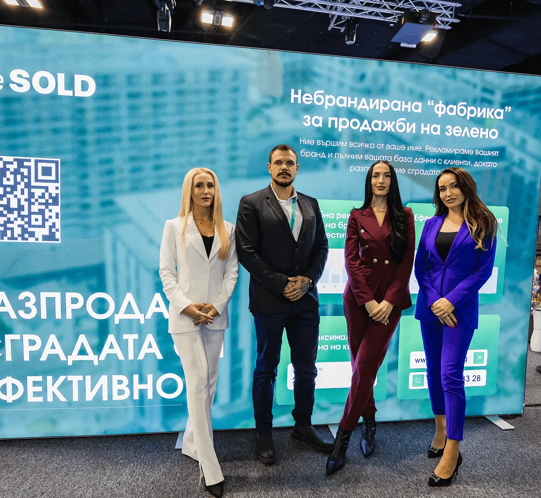 Четирима професионално облечени хора, стоящи пред голям екран с текст за продажби и брандиране.