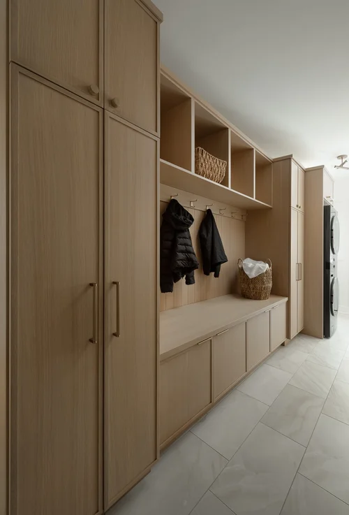 Floor-to-ceiling storage cabinets and hooks planned before construction for everyday gear
