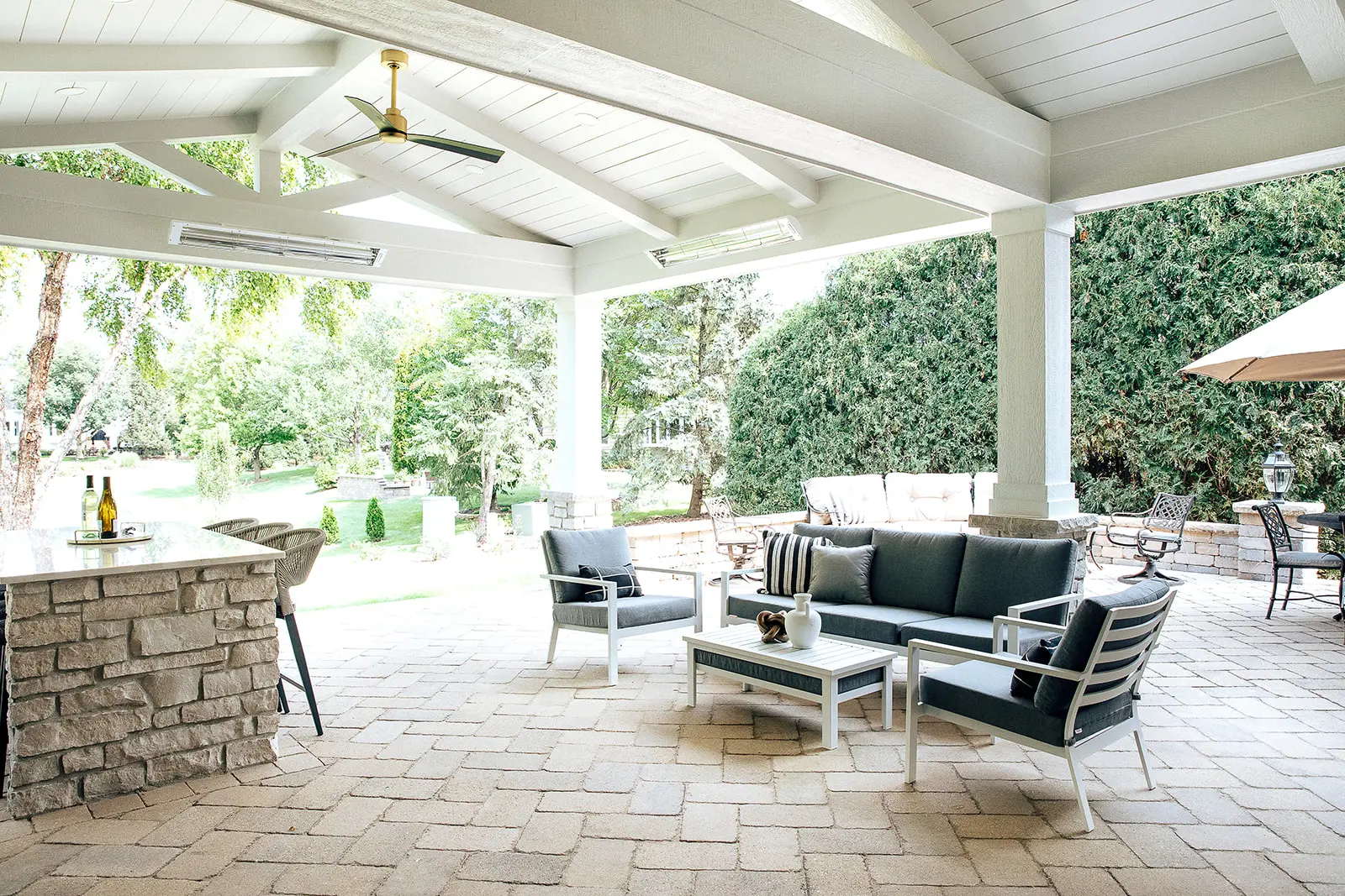 Covered outdoor living addition with stone bar and seating in West Chicagoland