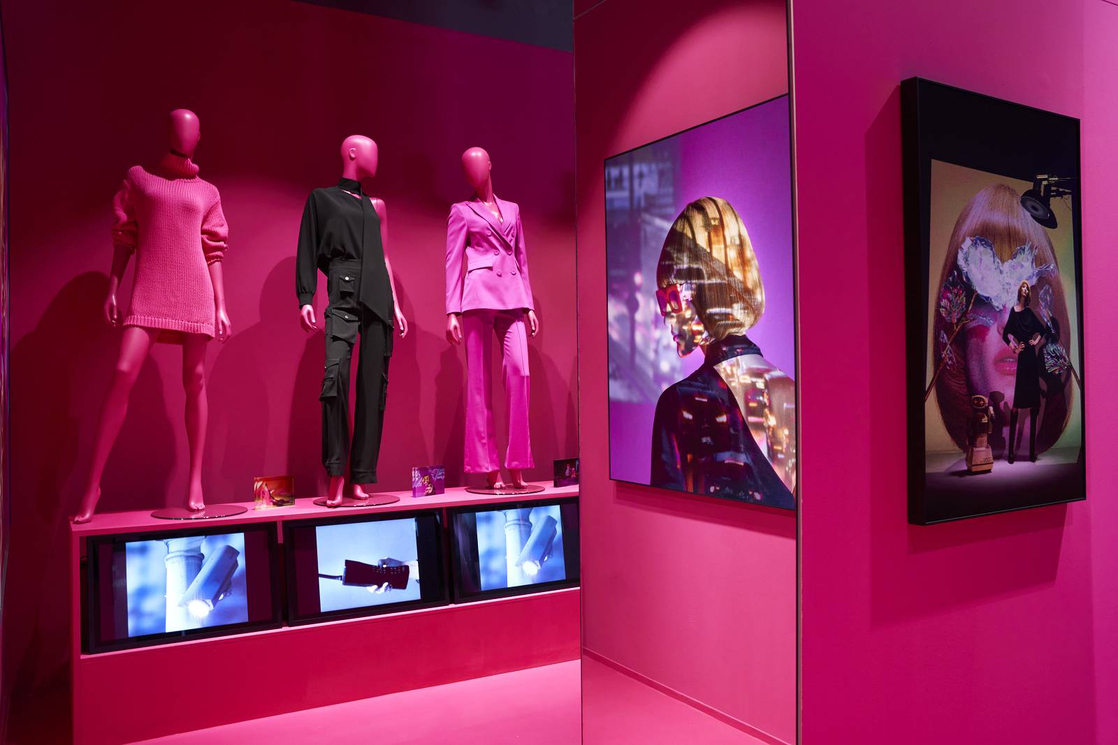 Pinker Innenraum eines Modeladens mit Postern, Bildschirmen, und Mannequins