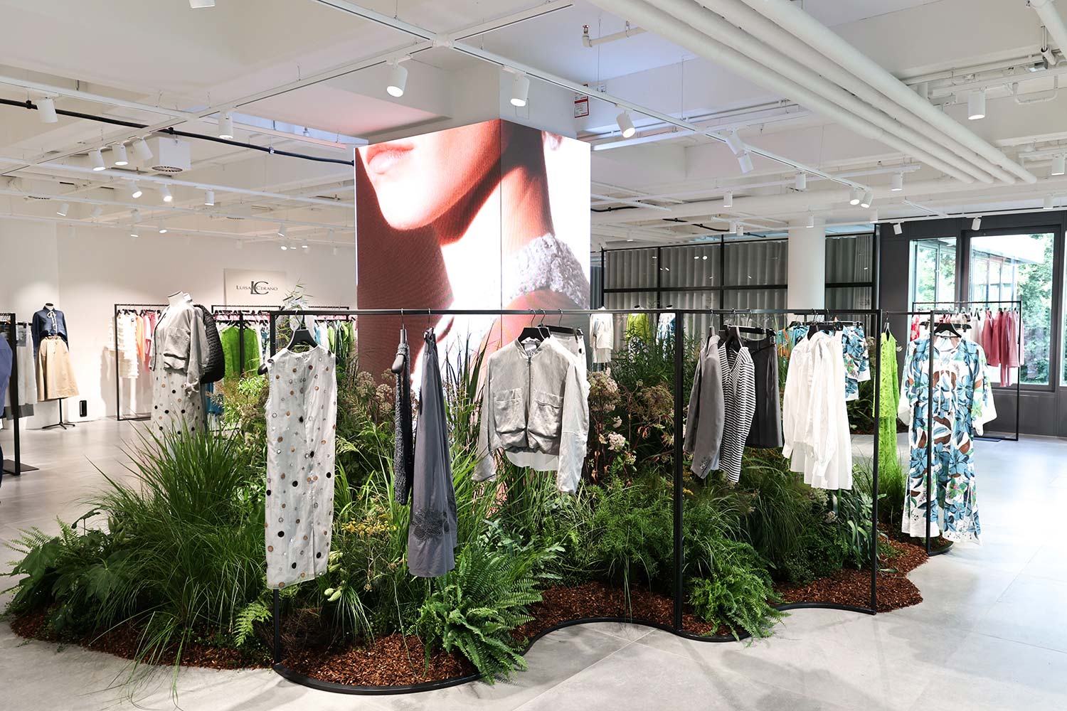 Rechteckige Säule aus LED-Panels inmitten eines modernen Fashion-Showrooms