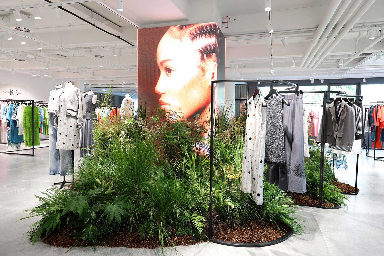 Rechteckige Säule aus LED-Panels inmitten eines modernen Fashion-Showrooms