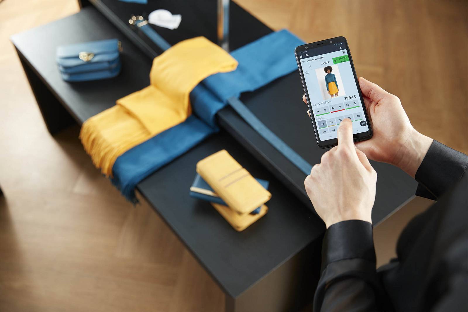 Person hält Smartphone, auf dem ein Business Blazer in verschiedenen Größen und für 39,99 € angezeigt wird.