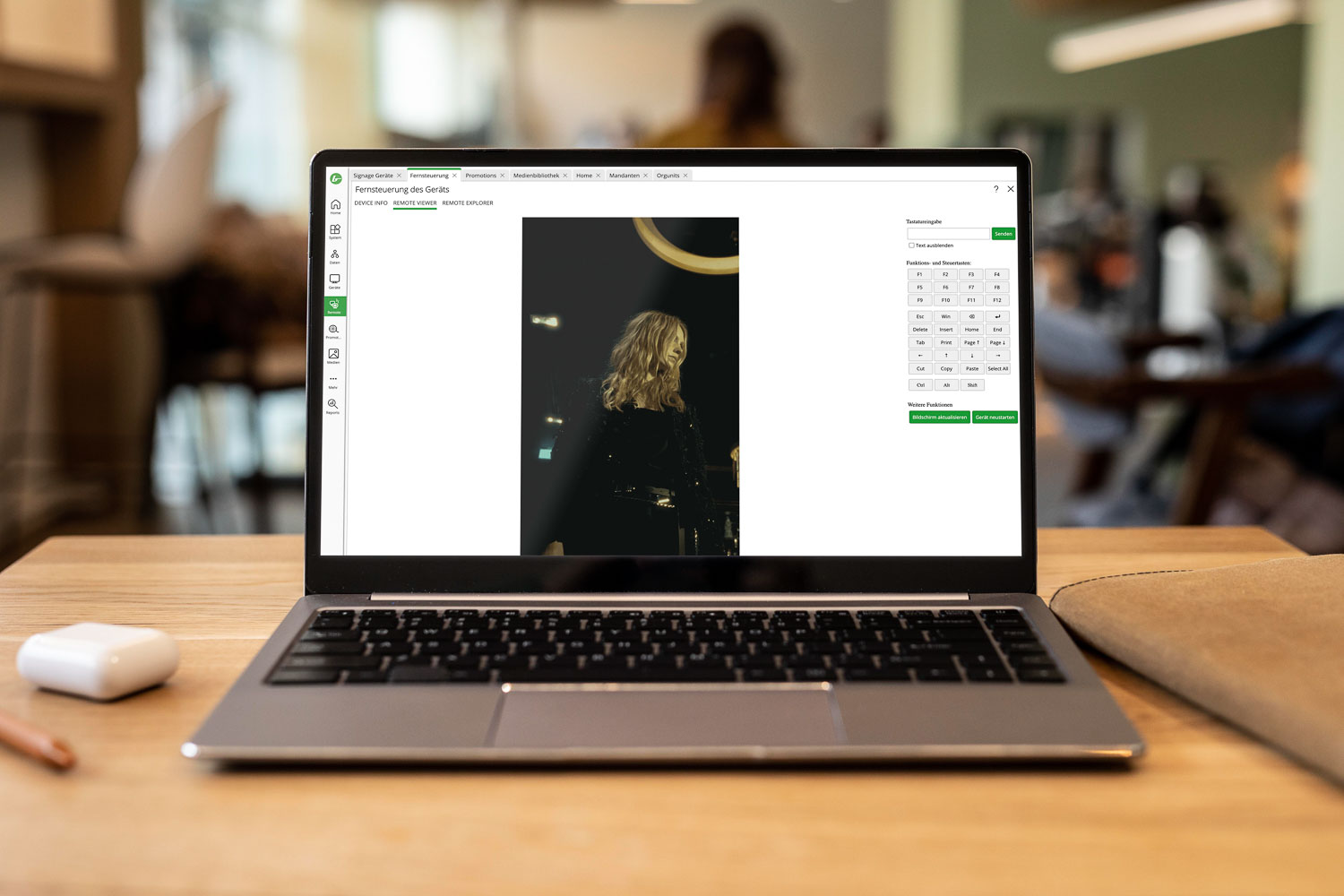 Laptop zeigt Fernsteuerungssoftware mit Bild einer Frau mit blonden Haaren auf dem Bildschirm in einem Büro.