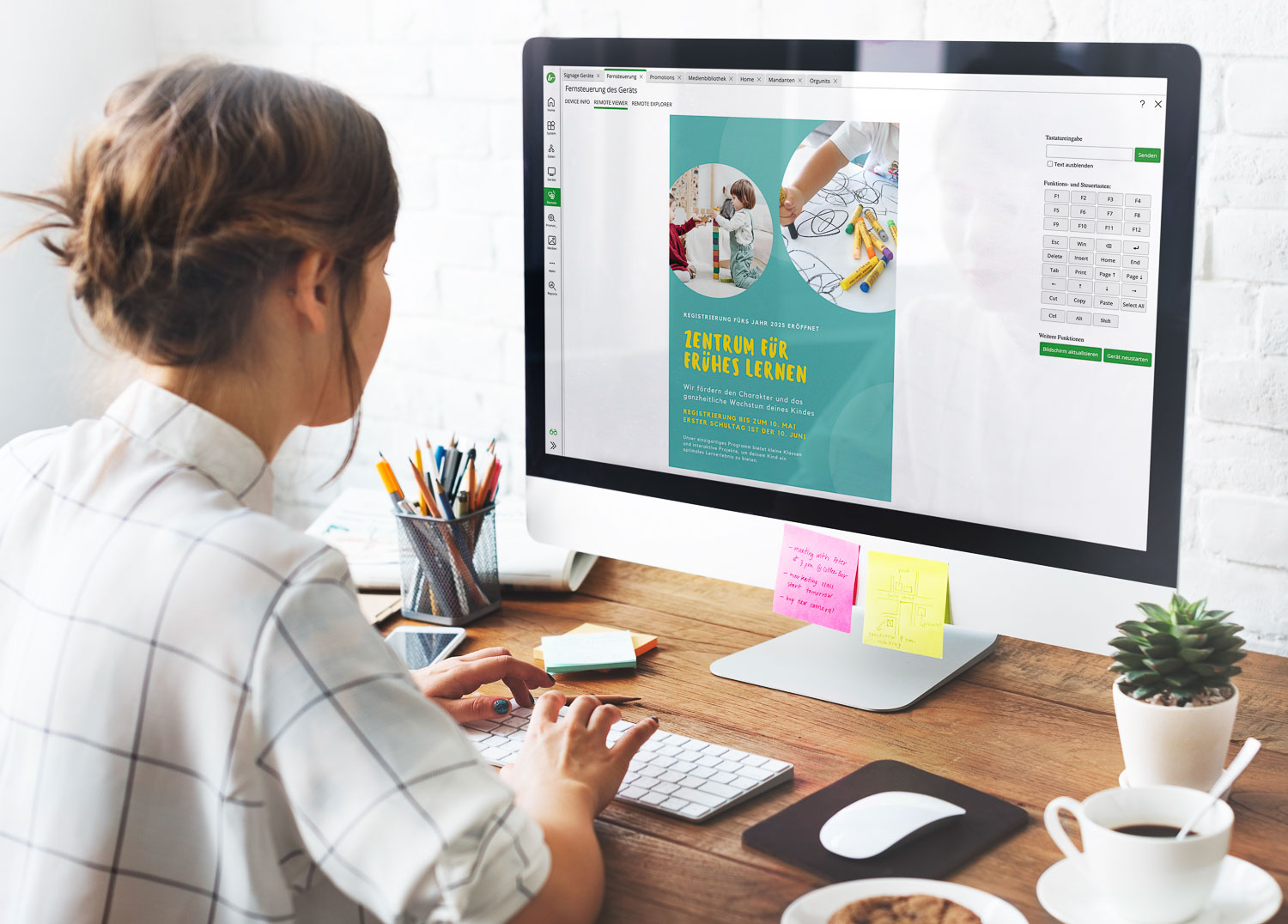 Frau arbeitet an einem Desktop-Computer mit einer Anzeige zur Fernsteuerung eines digitalen Lernzentrums auf dem Bildschirm.