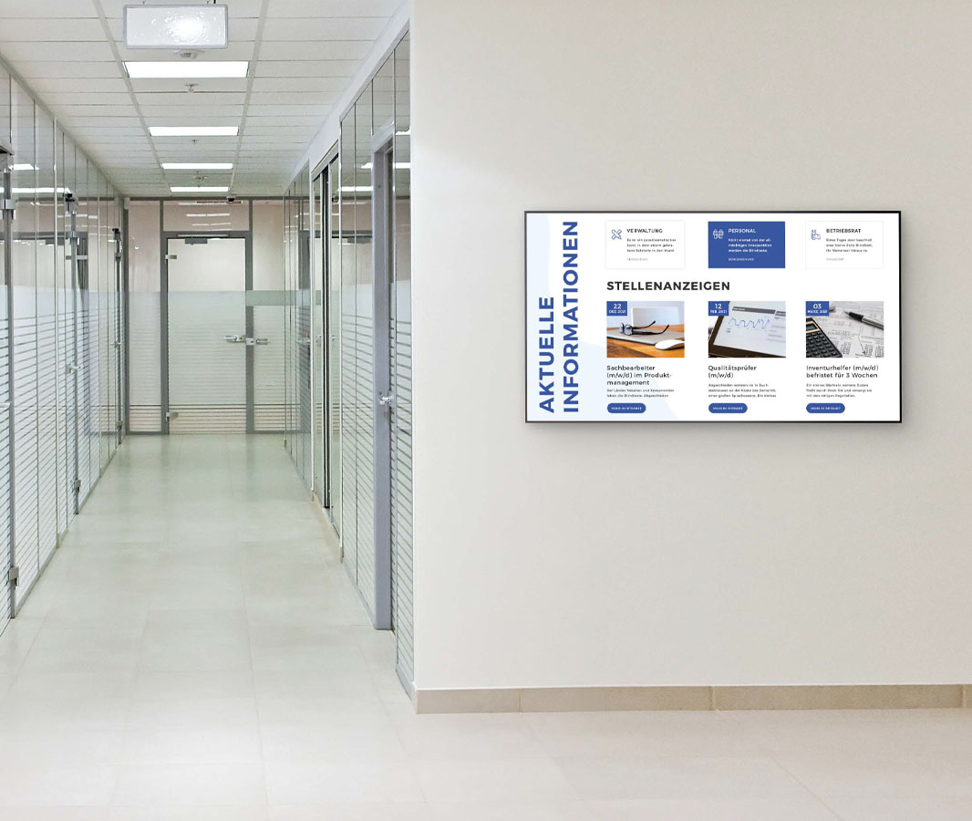 Moderner Büroflur mit Glaswänden und digitalen Stellenausschreibungen an der Wand.